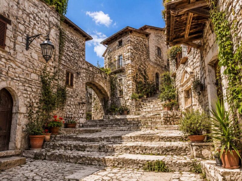 Scorcio del borgo di Sermoneta con scale in pietra, case storiche e piante vicino all’Agriturismo Ali e Radici